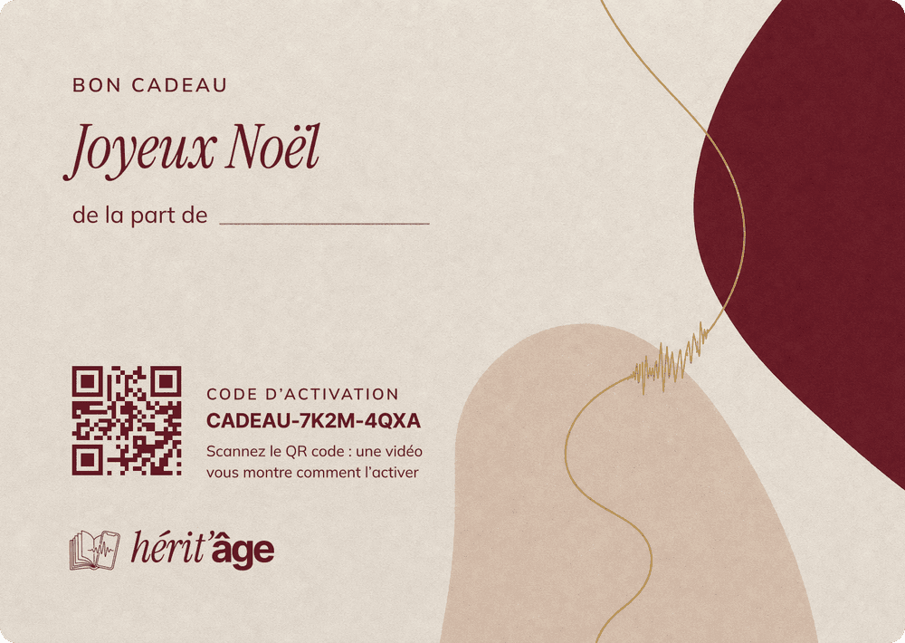 Bon cadeau cartonné Hérit’âge « Joyeux Noël » qui sort de son enveloppe blanche : ligne « de la part de » à remplir, code d’activation et QR code vers la vidéo qui explique l’activation